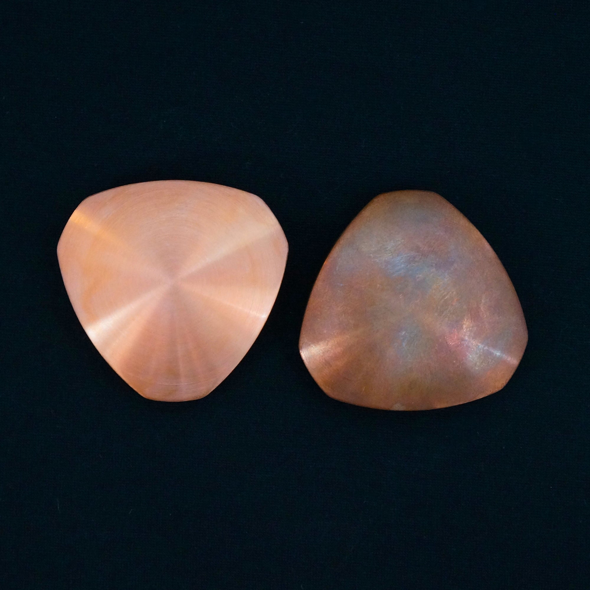 Two copper INDX focus tools, one that is brand new and the other that has a natural patina after frequent use.